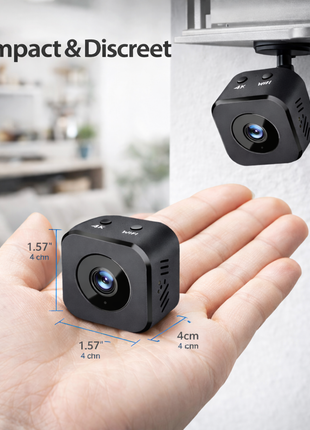 Mini câmara Wi‑Fi 4K preta numa mão, lente frontal visível
