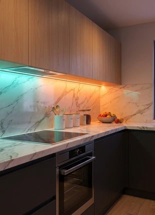 Fita LED RGB Wi‑Fi a iluminar a cozinha com tons verdes e laranja na bancada