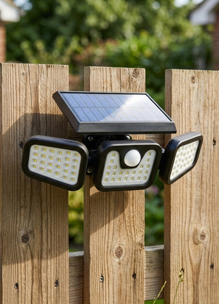 Holofote solar LED com sensor montado num muro de madeira com quatro focos