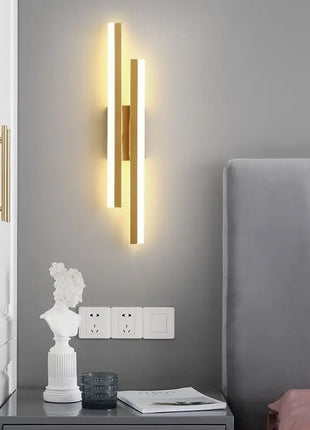 Aplique de parede LED minimalista dourado com barras verticais e luz quente
