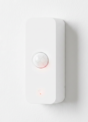 Sensor de movimento PIR branco com lente hexagonal e luzes indicadoras.